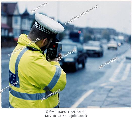 Metropolitan police officer with LTI 20-20 speed gun checking the speed of cars in the traffic
