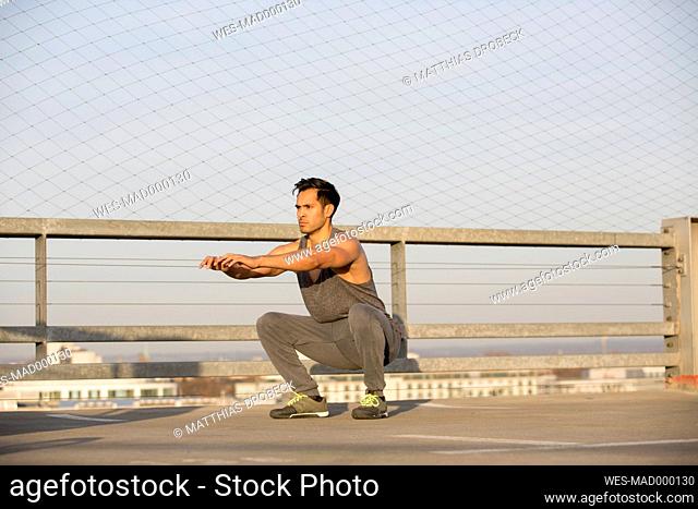 Muscular man doing squats