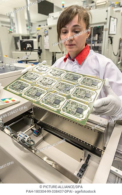 02 March 2018, Germany, Ingolstadt: A worker checking the production of circuit boards for radar sensors at Continental factory