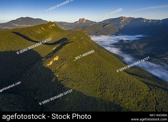 Aerial view of the Falgars sanctuary and the Catllaras s mountain range at sunrise with fog in the Lillet valley (Berguedá , Barcelona, Catalonia, Spain)