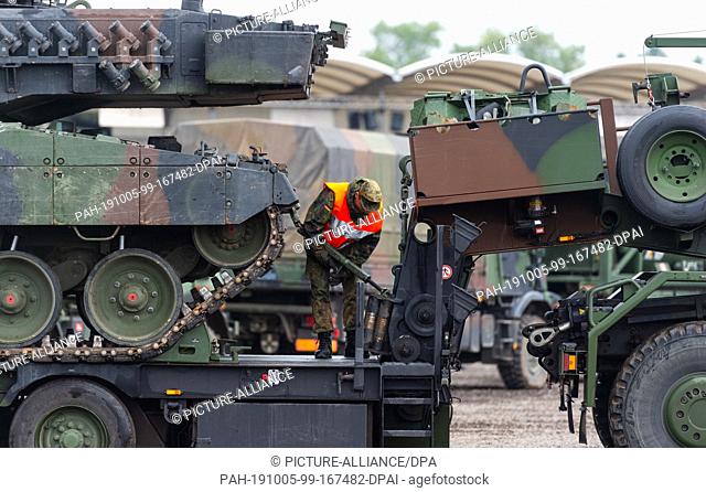 25 September 2019, Lower Saxony, Munster: A soldier of the Bundeswehr secures a Leopard 2A6 main battle tank on a low-loader during the information training...
