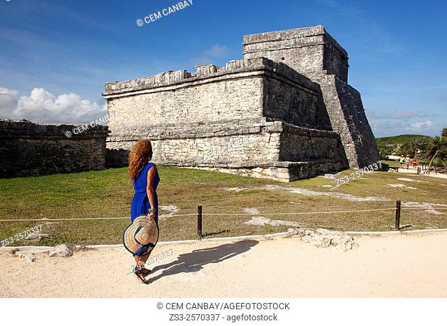 Woman posing in Mayan Ruins at Maya archeological site of Tulum near the Castle-Castillo, Quintana Roo, Yucatan Province, Mexico, Central America