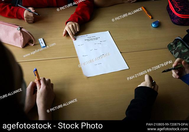 05 August 2021, Hamburg: Pupils of class 6a at the Goethe-Gymnasium in Hamburg-Lurup write their wishes for the new school year in a group work in the classroom...