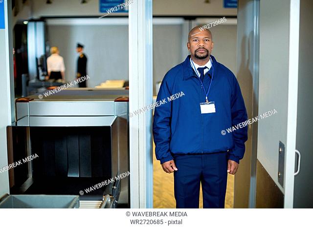Airport security officer standing in metal detector door