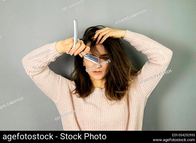 An emotional pretty European woman with beautiful hair and New Year's glasses, snowmen, standing in front of a gray background