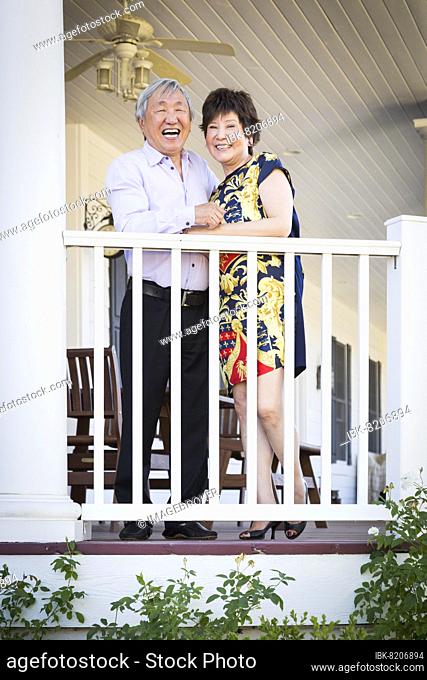 Attractive happy chinese couple enjoying their house outside