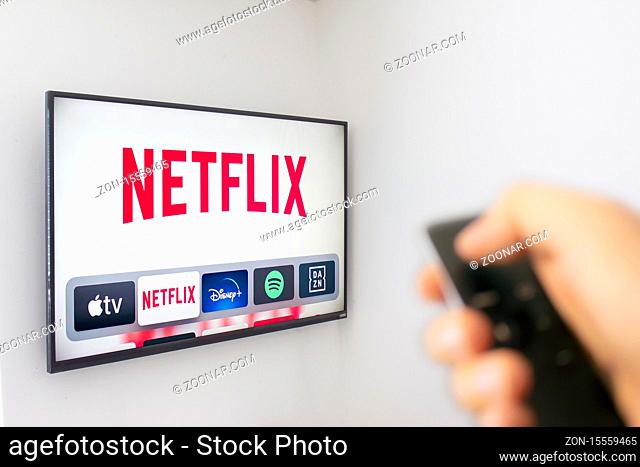 Calgary, Alberta. Canada Dec 9 2019: A Person holds an Apple TV remote using the new Netflix app with a hand. Netflix dominates Golden Globe Nominations