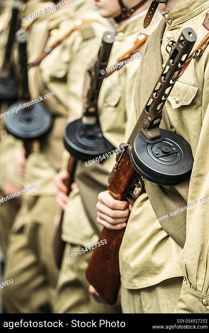 Re-enactos Dressed As Russian Soviet Soldiers Of World War II Holds Sub-machine Guns Weapon In Hands And Standing Order