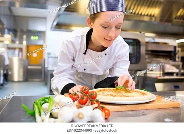 Woman preparing pizza in kitchen