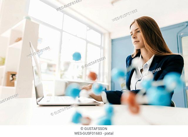 Female scientist studying molecule model