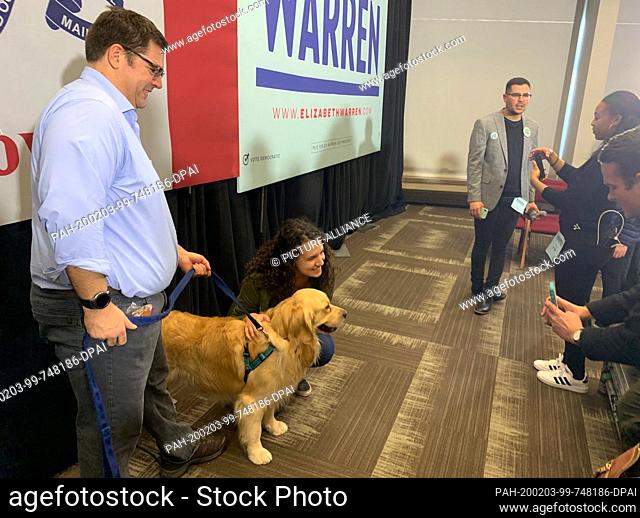 02 February 2020, US, Des Moines: Alex Warren, son of Elizabeth Warren, keeps the family dog Bailey on a leash, while he is photographed for Selfies with...