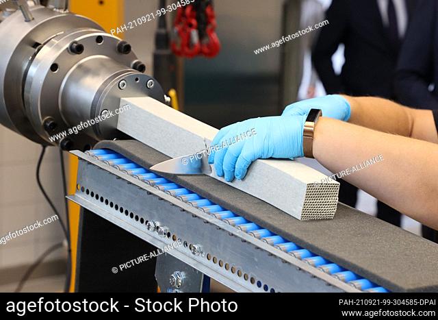16 September 2021, Thuringia, Hermsdorf: An employee works on the production of aluminum oxide honeycombs at the opening of the pilot center for powder...