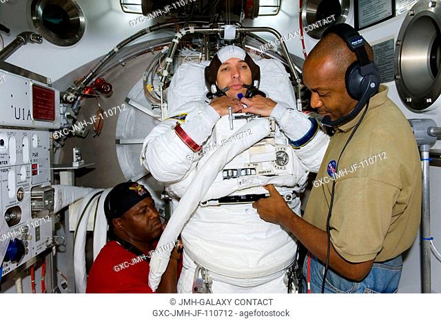 Astronaut Randy Bresnik, STS-129 mission specialist, participates in an Extravehicular Mobility Unit (EMU) spacesuit fit check in the Space Station Airlock Test...