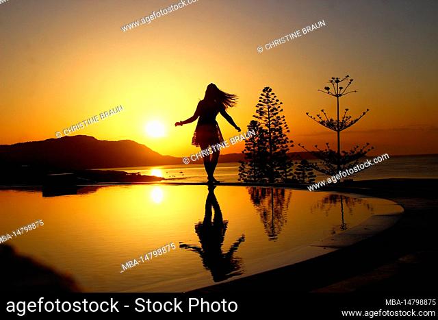 Young woman by the pool at sunrise, Kiotari, Rhodes, Greece