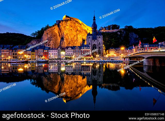 Night view of Dinant town, Collegiate Church of Notre Dame de Dinant over River Meuse and Pont Charles de Gaulle bridge and Dinant Citadel illuminated in the...