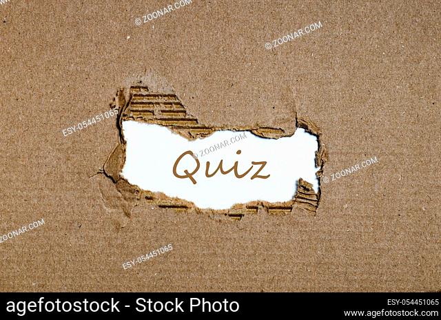 The word quiz appearing behind torn paper