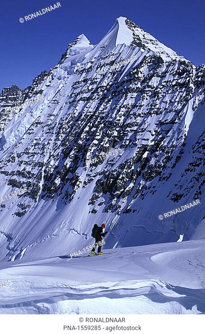 A ski mountaineer crossing a snow bridge over a crevasse on a glacier in eastern Greenland