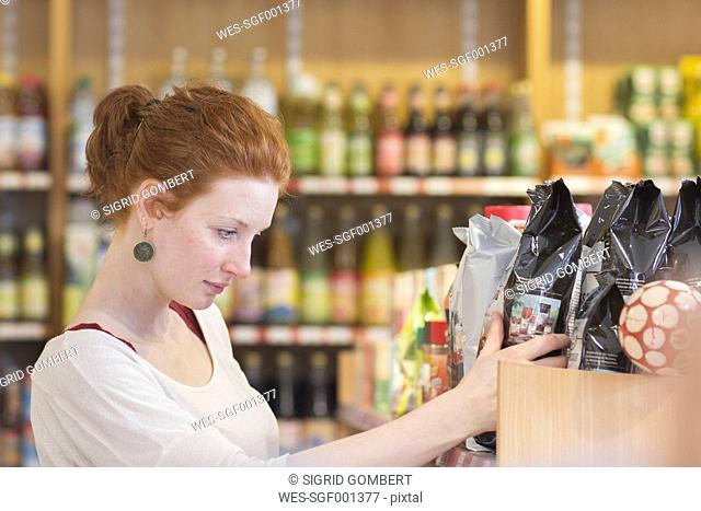 Female shop assistant sorting merchandise in wholefood shop