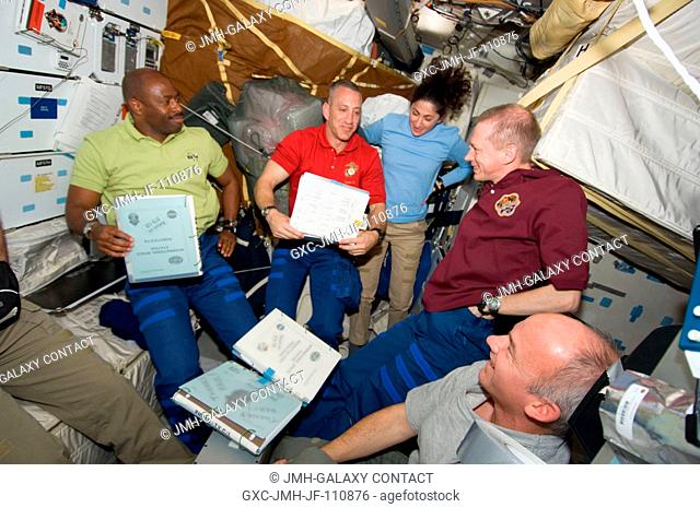 On Atlantis' middeck, from left, astronauts Leland Melvin, Charles Hobaugh, Nicole Stott, Frank De Winne and Jeffrey Williams discuss their roles for flight day...
