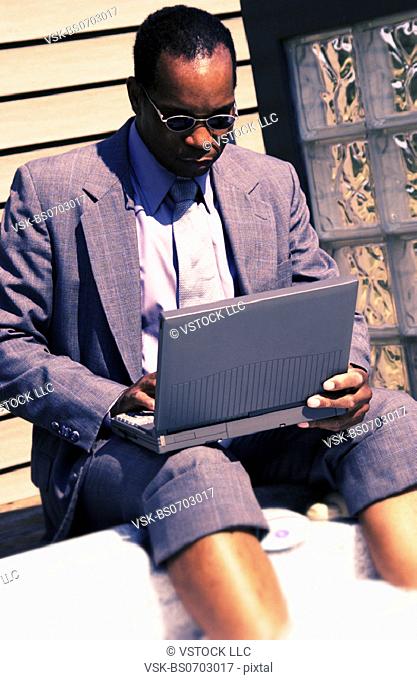 Businessman on laptop by hot tub
