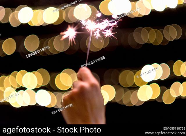 Close up view of woman hands holding sparkler