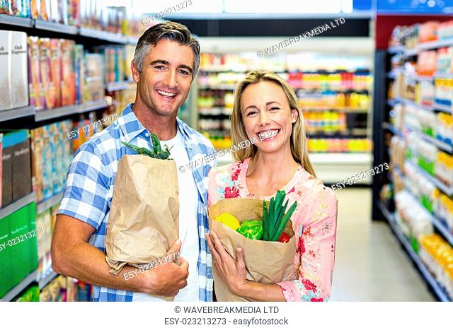 Smiling couple with grocery bags at the supermarket