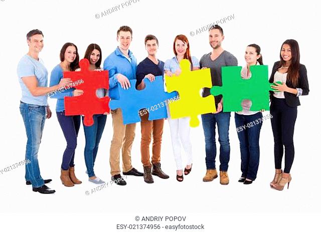 Group of people connecting puzzle pieces