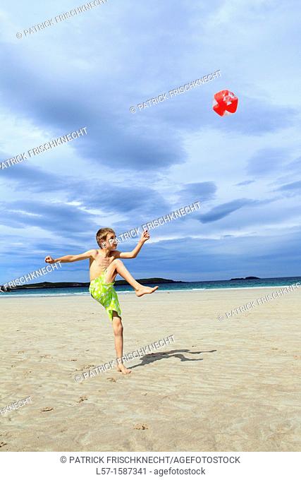 boy playing on sandy beach, Sutherland, Scotland