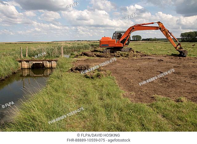 Using a digger for maintenance work on sluice gate at Deepdale Marsh north Norfolk