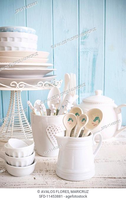 White crockery and cutlery against a light blue wooden wall