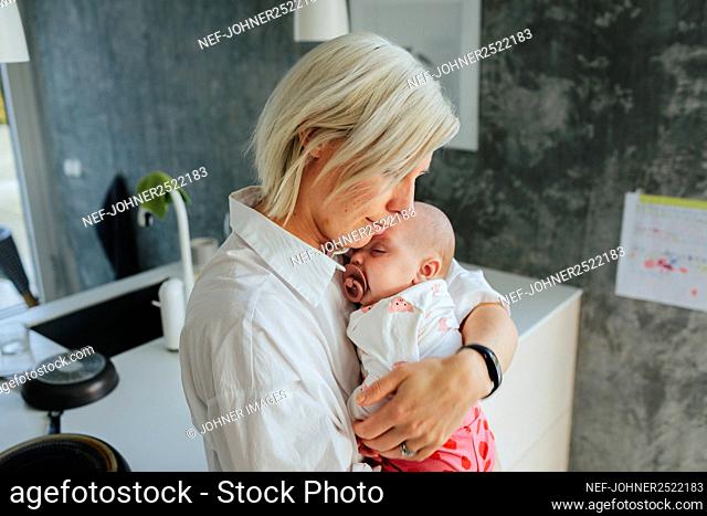 Mother hugging baby daughter