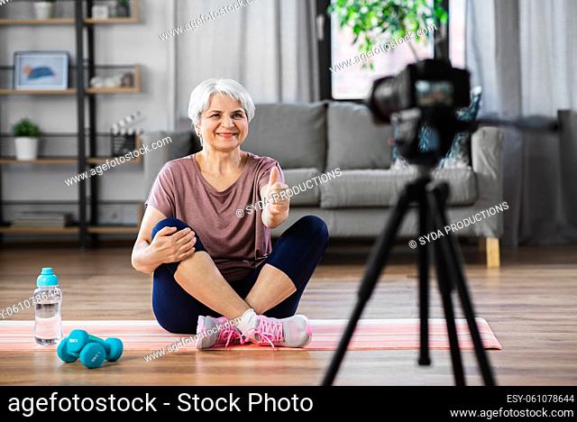 woman or fitness blogger with camera at home