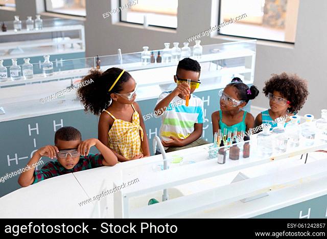 African american elementary school students performing chemical experiment in laboratory