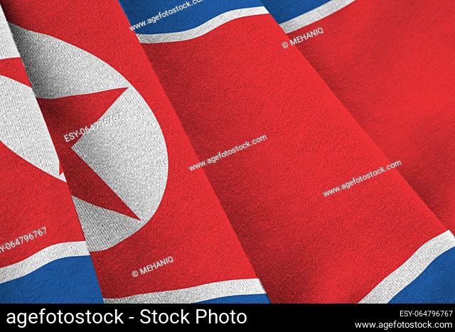 North Korea flag with big folds waving close up under the studio light indoors. The official symbols and colors in fabric banner