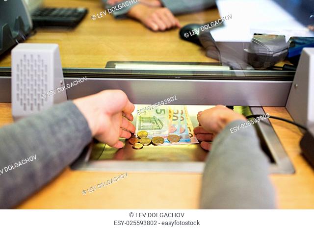 people, saving, currency exchange and finance concept - hands taking cash money at bank office