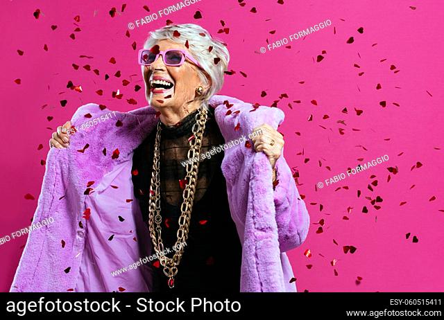 image of a beautiful and elegant old influencer woman. Cool grandmother posing in studio wearing fashionable clothes. Happy senior lady celebrating and making...