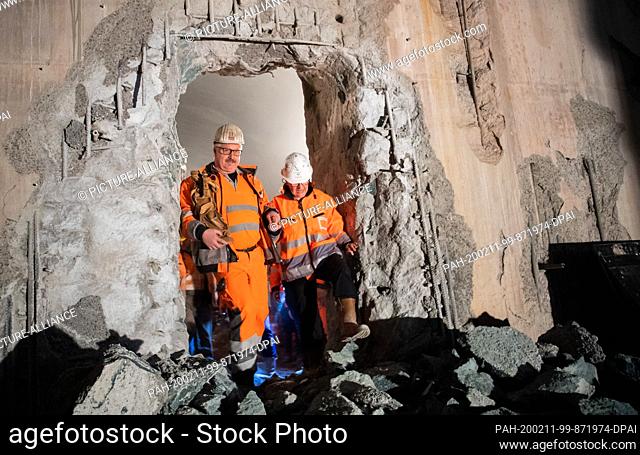 11 February 2020, Baden-Wuerttemberg, Stuttgart: Construction workers walk through the tunnel breakthrough with a figure of Saint Barbara
