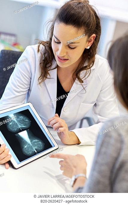 Mammogram. Mammography. Breast Cancer. Doctor showing image tablet. Doctor attending to patient medical consultation. Office