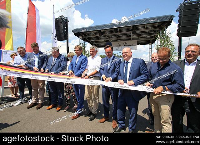 30 June 2022, Hessen, Schwalmstadt: The ribbon is symbolically cut to mark the opening of the A49. After eleven years of construction
