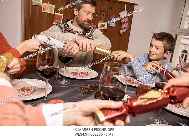 Pulling ends of Christmas crackers at family table