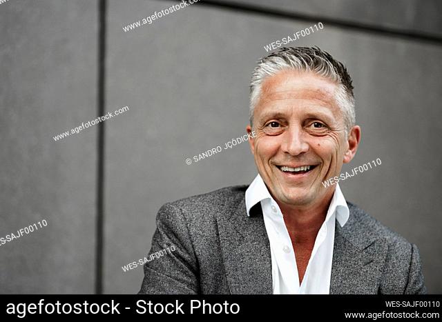Happy male expertise in front of gray wall