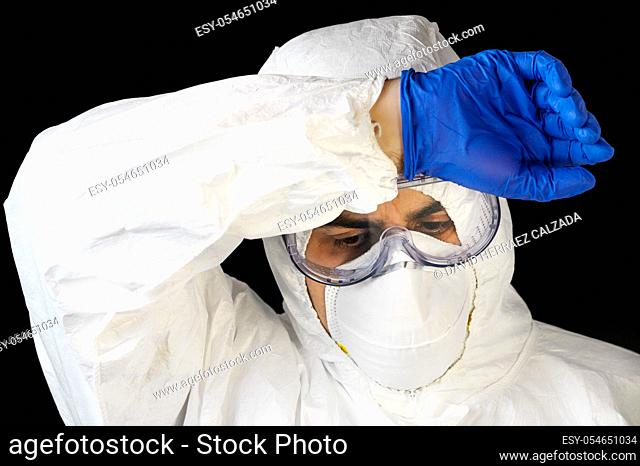 COVID-19. Exhausted Doctor, in personal protective equipment, worried as the coronavirus infected cases and death tolls rises