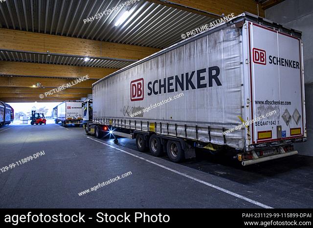PRODUCTION - 21 November 2023, Mecklenburg-Western Pomerania, Rostock: Pallets and transported goods are reloaded into wagons by trailers from logistics company...
