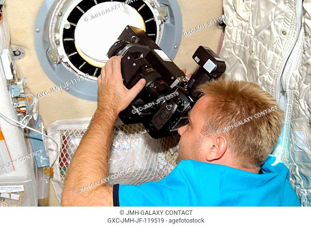 Russian cosmonaut Maxim Suraev, Expedition 2122 flight engineer, uses science hardware RUSALKA at a window in the Zvezda Service Module of the International...