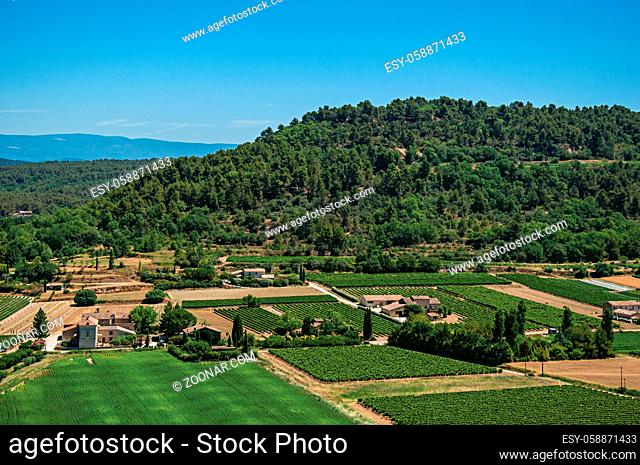 Panoramic view of the fields and hills of Provence near Menerbes, under sunny blue sky. Located in the Vaucluse department, Provence-Alpes-Cote d Azur region