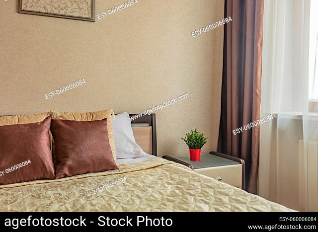 pillow on bed and nightstand in cozy comfortable bedroom in beige color