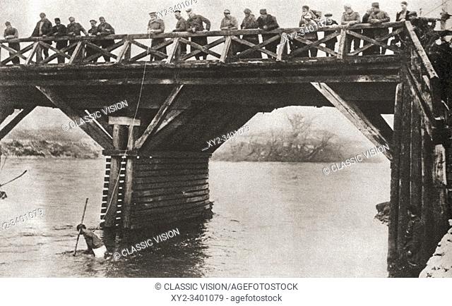 Bulgarian soldiers fishing for guns in the river at Nish, or Niš, Serbia, after the Serb evacuation in 1916. From The Pageant of the Century, published 1934