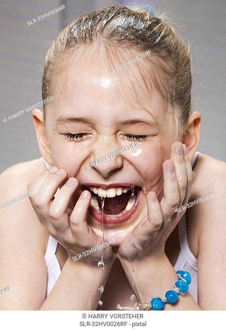 Laughing girl washing her face