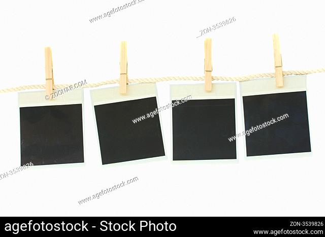 old fashioned photo paper hanging on rope isolated on white background