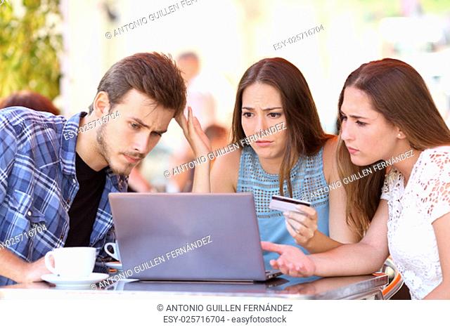 Three shopper friends buying online with credit card finance problems in a coffee shop